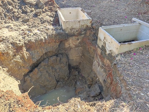 Excavated chamber and pipe area during a water leak repair in Sicily