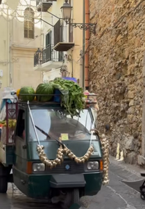 A mobile fruit and vegetable truck in Cefalu doing his rounds.